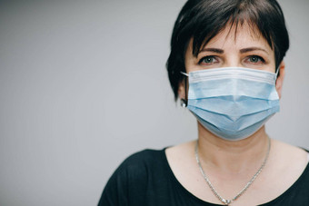 高级女人需要医疗面具呼吸深深相机灰色背景健康护理医疗概念