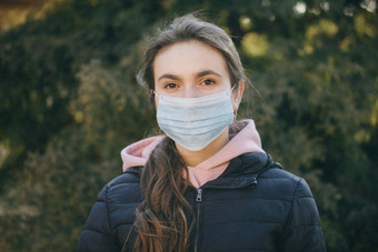 生病的女孩穿保护流感大流行漂亮的年轻的高加索人女孩采取医疗面具户外女孩穿医疗面具冠状病毒科维德疫情
