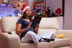女人坐着莲花位置沙发上社会媒体写作圣诞节电子邮件