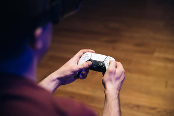 特写镜头男人的手玩视频游戏游戏控制台前面宽屏男人。玩玩站双感觉控制器色彩斑斓的灯