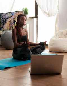 黑色的女人坐着瑜伽席练习平静
