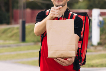 食物交付男人。订单餐厅英俊的年轻的男人。t恤帽<strong>快乐</strong>交付工人持有包食物微笑交付服务通<strong>过</strong>通<strong>过</strong>