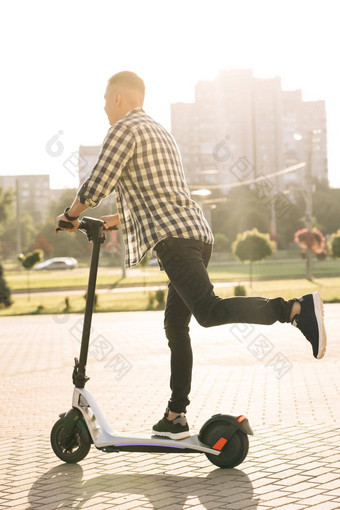 赶时髦的人男人。通勤工作城市电踏板车环保运输快速度开车电运输男人。骑埃斯库奥特生态城市生活方式