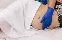 理疗师女人按摩肚子怀孕了女人担架怀孕了女人访问妇科医生医生医院医疗诊所怀孕顾问妇科概念