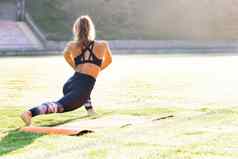 年轻的高加索人适合体育运动女人伸展运动身体温暖的锻炼户外女孩运动服装练习早....太阳健康幸福