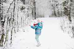 孩子女孩冬天玩雪公园户外孩子摇雪冷杉树冬天时间幸福概念下雪天气