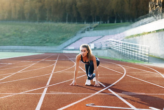 女运动员开始冲刺运行跟踪跑步者采取开始块运行跟踪慢跑者活动女运动员女运动员有氧运动练习锻炼概念