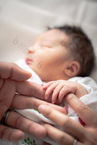 新生儿<strong>婴儿婴儿</strong>女孩毯子用襁褓包包装<strong>小手</strong>手指父亲母亲的手指睡觉和平