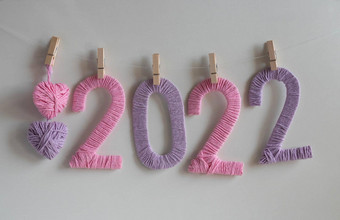 数字使粉红色的淡紫色线程白色背景挂夹淡紫色粉红色的针织心概念一年