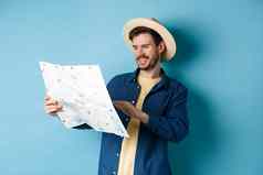 英俊的微笑旅游稻草他地图选择旅行路规划假期站蓝色的背景