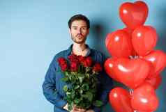 浪漫的男人。红色的玫瑰红色的心气球皱纹嘴唇吻使惊喜情人节一天站蓝色的背景