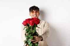 英俊的的男朋友给花束玫瑰使惊喜礼物浪漫的日期情人节一天站情人白色背景
