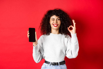 有吸引力的女人智能手机显示标志空电话斯雷恩推荐购物应用程序站红色的背景