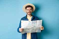 快乐积极的的家伙假期相机持有地图微笑兴奋夏天旅行站蓝色的背景