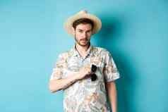 英俊的旅游夏威夷衬衫夏天他把太阳镜口袋里假期站蓝色的背景