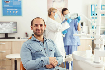 肖像男人。病人坐着牙科椅子准备口腔学咨询