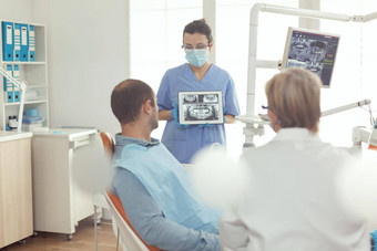 牙齿矫正医师护士持有数字平板电脑牙射线照相法屏幕