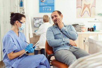 口腔学家护士解释医疗过程生病的病人