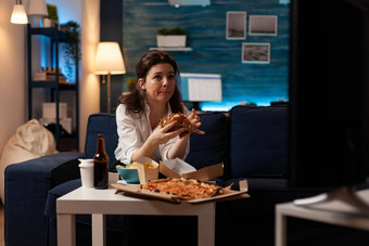 女人坐着沙发吃美味的美味的汉堡看<strong>纪录</strong>片电影