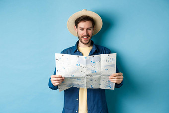 快乐的旅游夏天他规划旅行路线假期sighseeing地图微笑兴奋站蓝色的背景