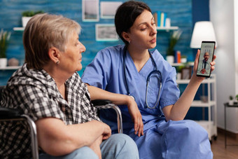 护理首页女工人帮助退休禁用上了年纪的女人视频调用智能手机