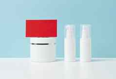 空白红色的纸业务卡集塑料白色容器化妆品蓝色的背景品牌概念促销活动产品示范