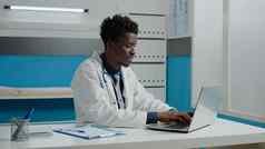 非洲美国医生移动PC坐着桌子上