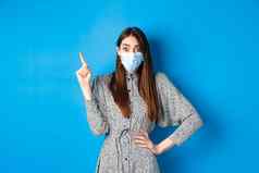 健康的人科维德流感大流行概念兴奋女人医疗面具指出上左角落里站蓝色的背景