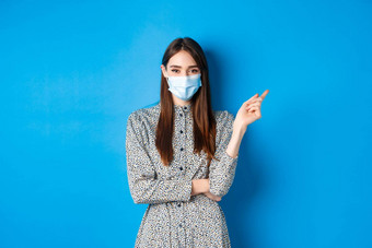 科维德社会距离医疗保健概念漂亮的夫人医疗面具显示指出微笑广告蓝色的背景