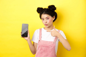 在线购物概念时尚的亚洲女人粉红色的化妆指出空智能手机斯雷恩显示好交易黄色的背景