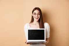 快乐女人眼镜显示移动PC屏幕微笑演示互联网促销交易站米色背景