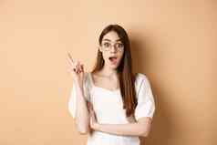 有创意的年轻的女人眼镜投手的想法提高手指尤里卡标志喘气计划站米色背景