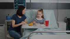 妈妈。坐着生病的孩子病人吃健康的食物午餐医院病房