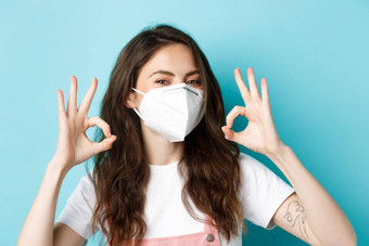 科维德社会距离封锁概念年轻的积极的女人呼吸器显示迹象点头批准赞扬预防措施流感大流行蓝色的背景