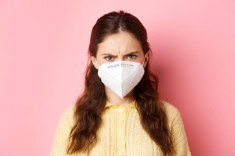 预防措施健康护理概念关闭愤怒的女人呼吸器皱着眉头审判的脸人面具站粉红色的背景