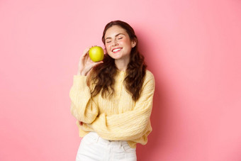 医疗保健<strong>口腔</strong>学人概念快乐女孩显示白色完美的牙齿微笑绿色苹果吃<strong>健康</strong>的食物水果站粉红色的背景