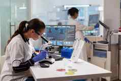 生物技术科学家显微镜分析遗传的材料