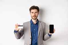 在线购物有胡子的男人。业务西装显示塑料信贷卡空智能手机屏幕站白色背景