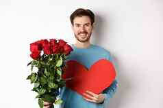 浪漫的人英俊的微笑男人。持有花束玫瑰大红色的心情人节一天日期女朋友站白色背景