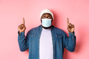 冠状病毒生活方式全球流感大流行概念感兴趣黑色的男人。广告指出盯着促销提供站粉红色的背景