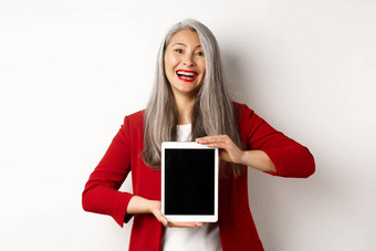 业务快乐的亚洲女商人红色的夹克显示数字平板电脑屏幕微笑<strong>介绍</strong>应用程序促销<strong>活动</strong>白色背景
