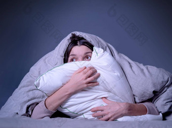 女人覆盖毯子担心失眠压力