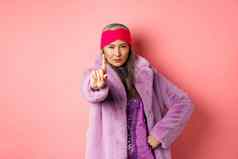 时尚购物概念亚洲高级女人显示快手势摇晃扩展手指停止警告确定相机穿时尚的紫色的衣服