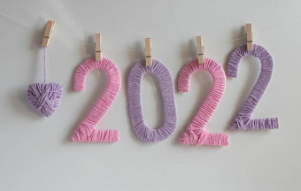 数字使粉红色的淡紫色线程白色背景挂夹淡紫色针织心概念一年