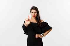 时尚美自信夫人黑色的衣服显示手指停止手势禁止不赞成站白色背景