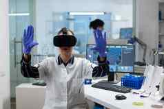 生物学家研究员穿虚拟现实耳机检查生物化学实验