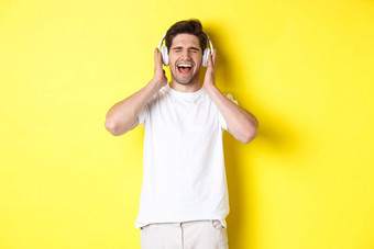 快乐的家伙听音乐耳机购买耳机黑色的星期五站黄色的背景