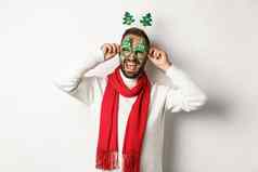 圣诞节一年庆祝活动概念英俊的的家伙庆祝把聚会，派对眼镜附件笑快乐站白色背景