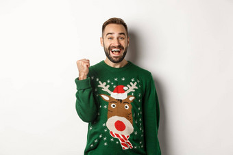 一年假期庆祝活动兴奋快乐的家伙圣诞节毛衣使拳头泵并接收礼物欢乐站白色背景