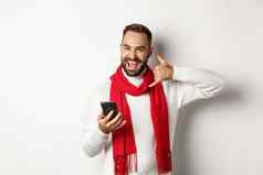 快乐有胡子的的家伙持有智能手机显示电话标志调用站圣诞节毛衣围巾白色背景